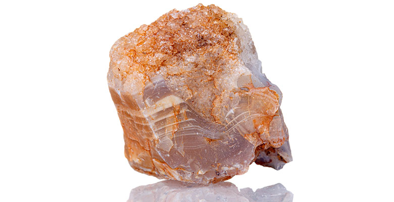 Pedra bruta de dolomita natural numa mesa branca.