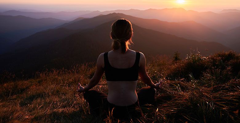 Mulher meditando em uma colina