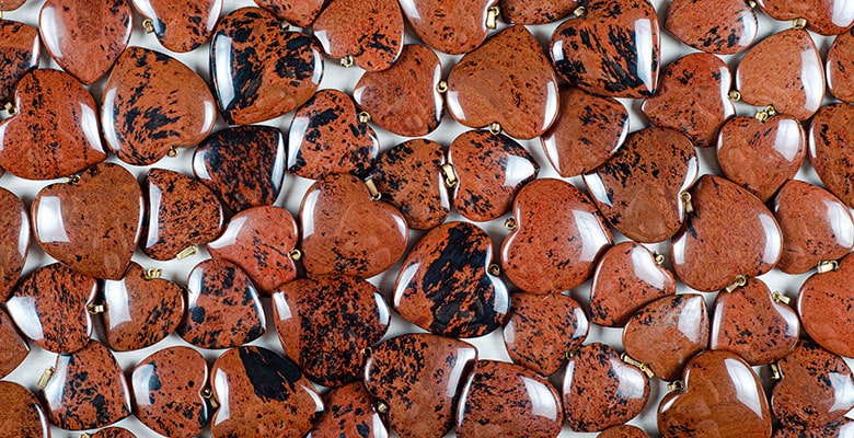 Várias pedras de obsidiana mogno no formato de coração.