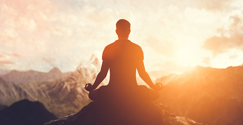 Homem meditando na natureza.