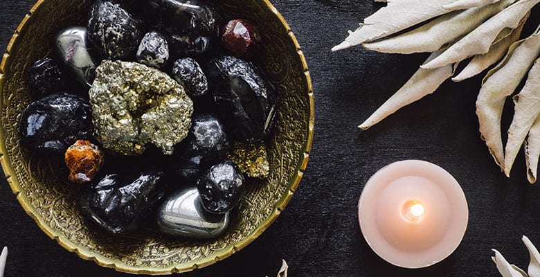 Obsidianas e outras pedras naturais sobre uma mesa para meditação.