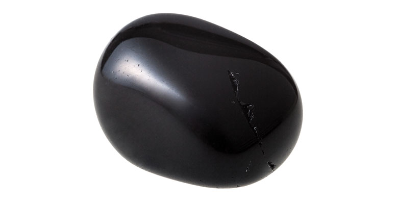 Pedra natural de ônix preto em um fundo branco.