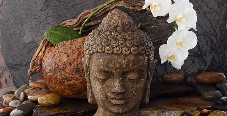Rocha de bronzita com uma estátua de Buda na frente, representando uma cena de decoração espiritual ou contemplativa
