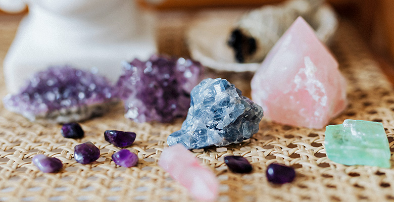 Mesa de madeira com pedras brutas naturais como ametista, quartzo rosa, jade e sodalita